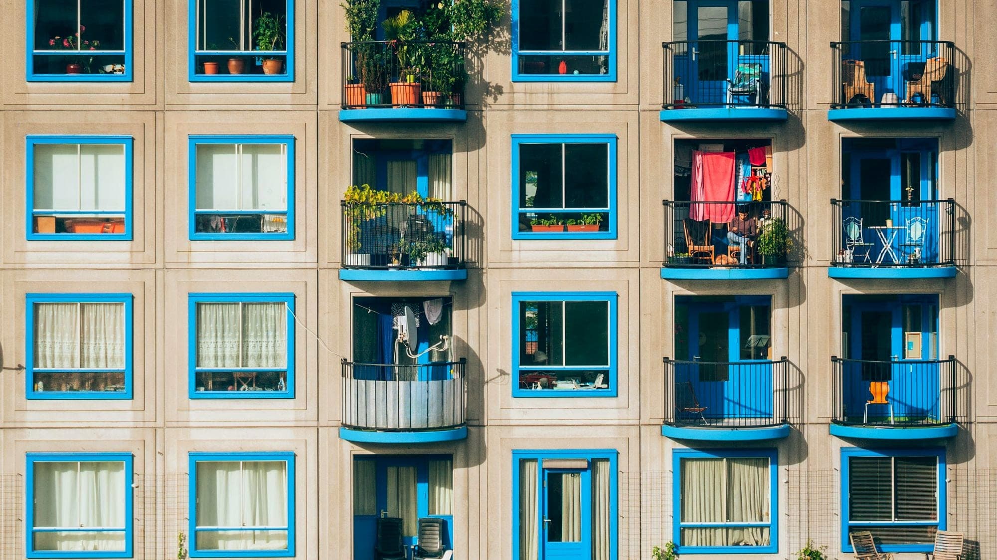 An apartment building with blue framed windows and balconies