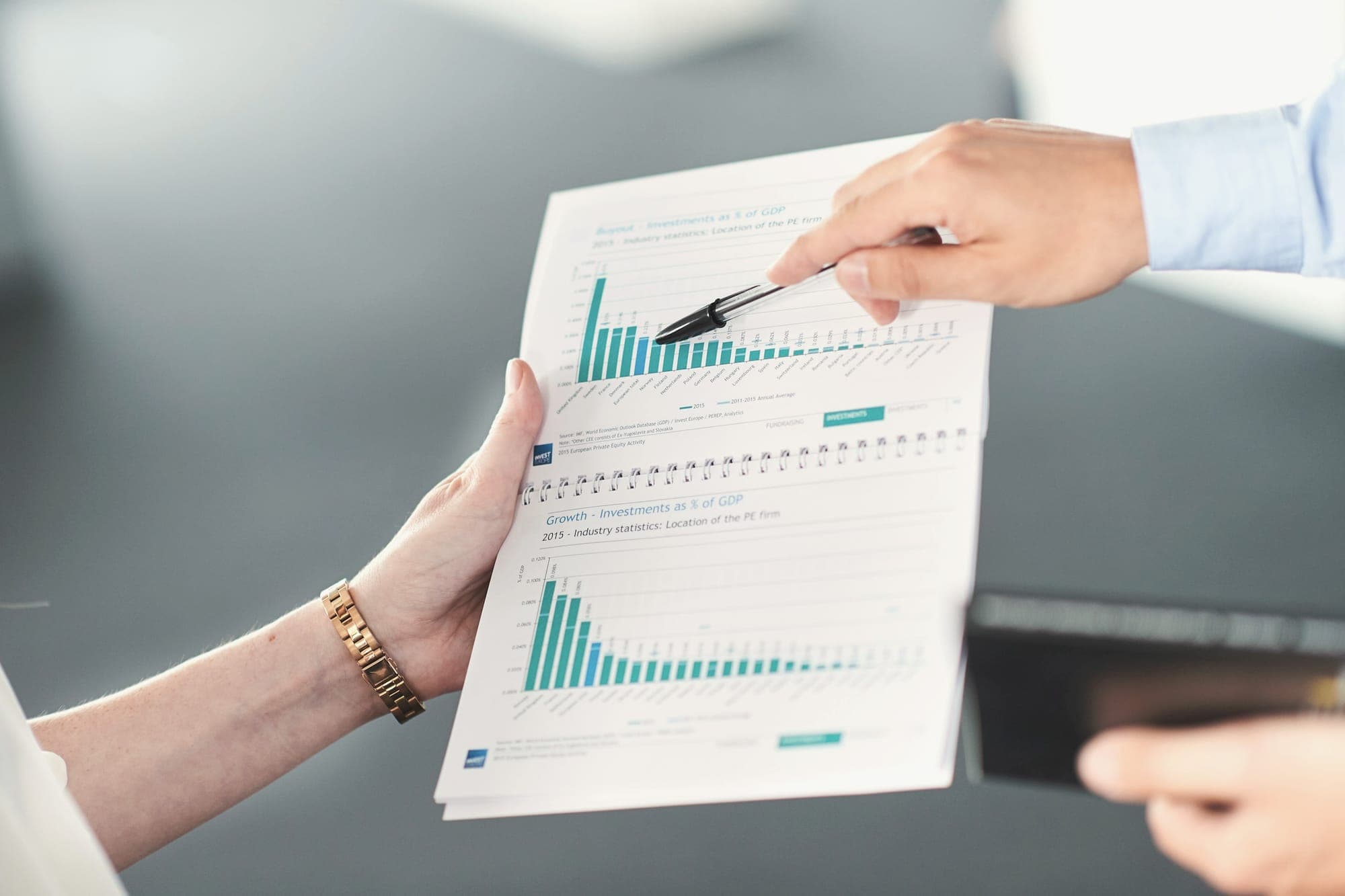 Two people looking over a printed report with bar charts